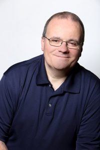 Photo of Mike, wearing glasses and a blue polo shirt. 