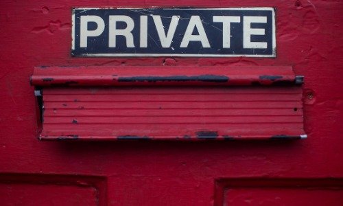 Red door with mail slot and the word "PRIVATE" in white letters.