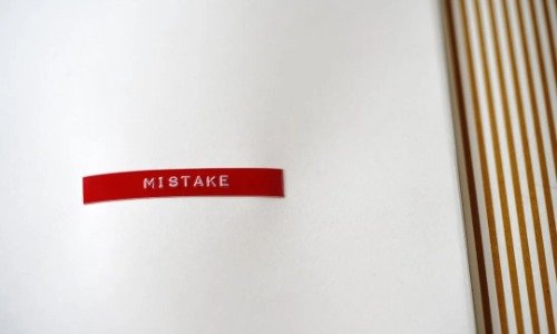 Red label on a white background with text that reads "Mistake"